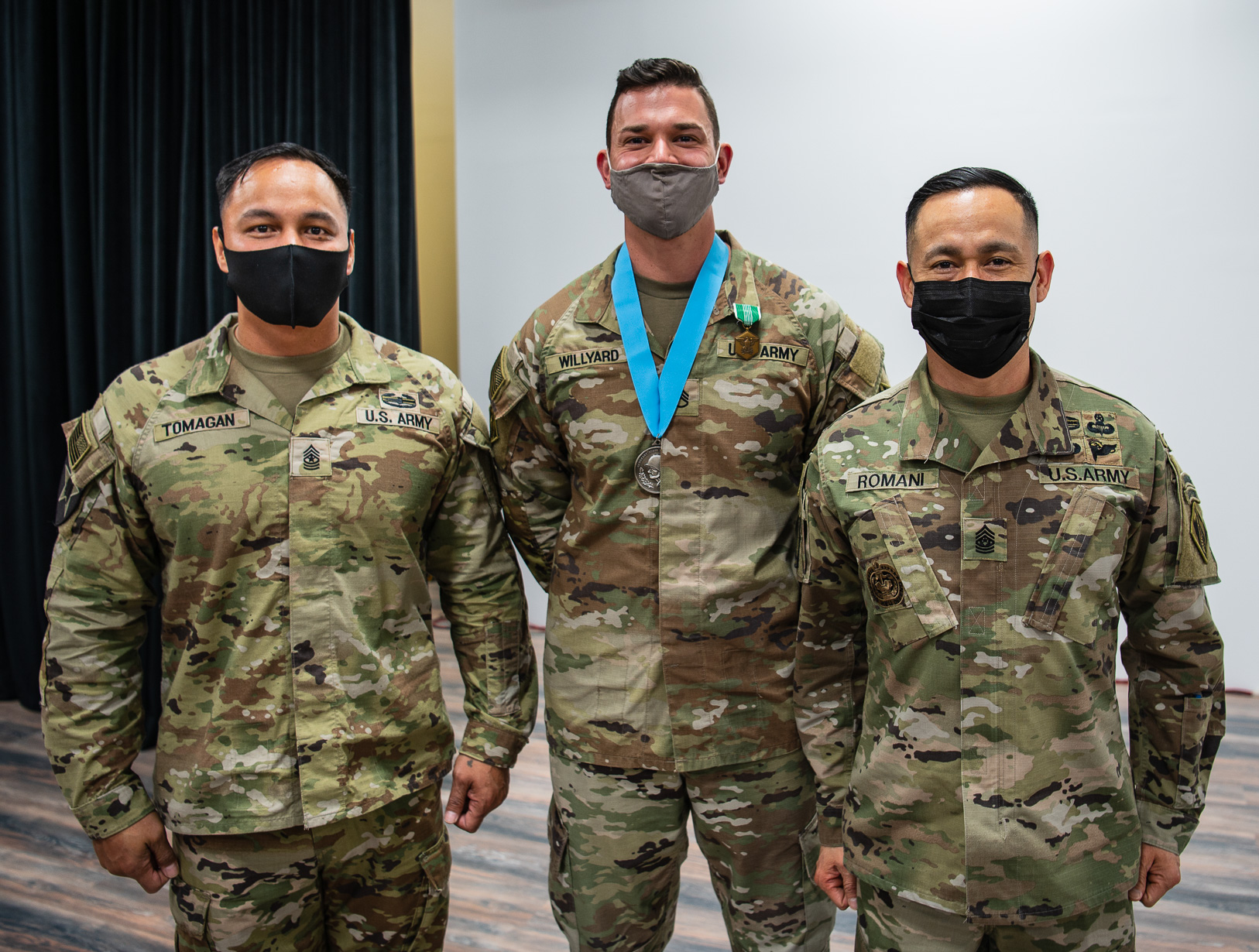 Sgt. Maj. Jun Tomagan (left), Staff Sgt. Mitchell Willyard, and Command Sgt. Maj. Delfin Romani (right), pose for photos.